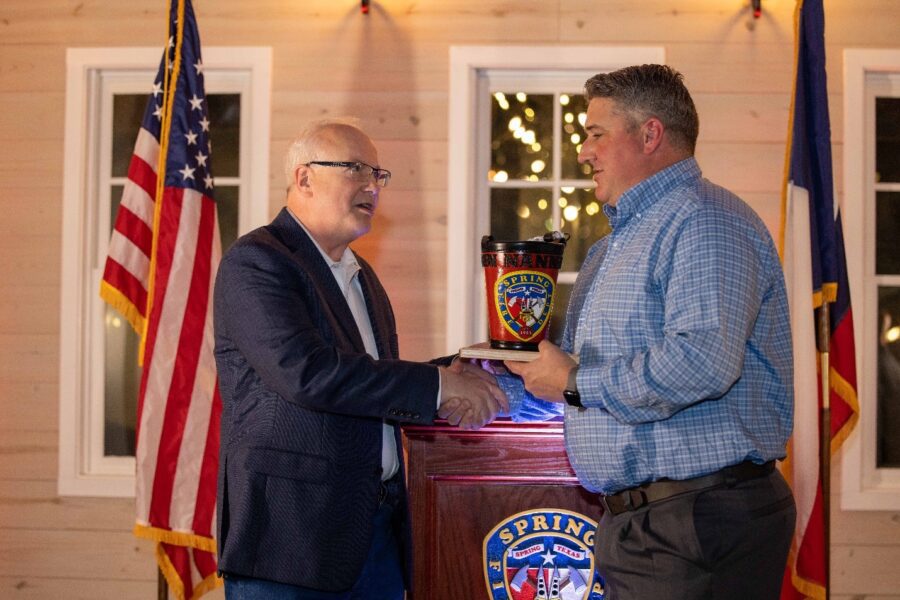 Two men shaking hands at a podium.