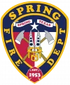 Spring Fire Department badge logo featuring two axes, a star, and the text “Spring Texas” and “Est 1953” on a shield with red, white, and blue background.